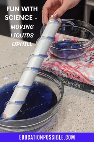 12" 1/2" PVC pipe with small, clear tubing wrapped around it. Purple liquid in bottom bowl that pipe is sitting on. Two books hold a smaller bowl with purple liquid. White text on top of image on left reads Fun with Science - moving liquids uphill.