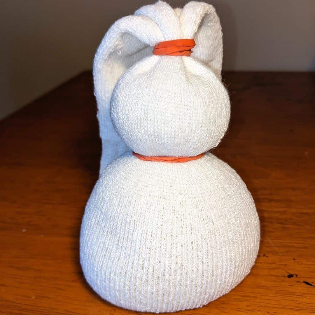 Sock filled with rice, tied with two rubber bands to create a snowman shape.