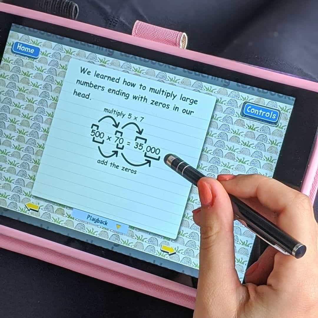 Girl holding a tablet answering a math problem.