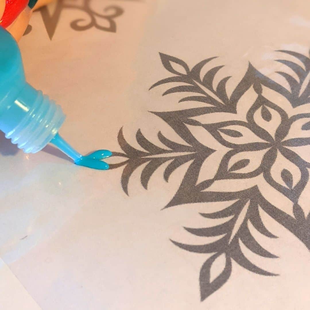 Using blue puffy paint to go over snowflake template.