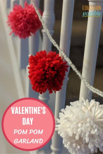 White, red and pink yarn pom-pom garland hanging on railing.