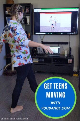 Teen girl dancing along with a video on TV.