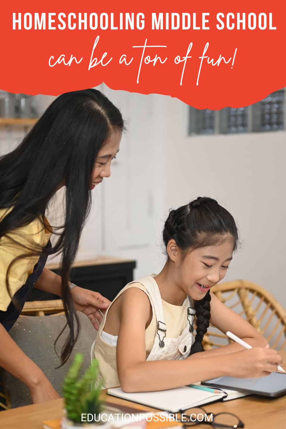 Asian mom and tween daughter doing school at dining room table. Girl writing on tablet.