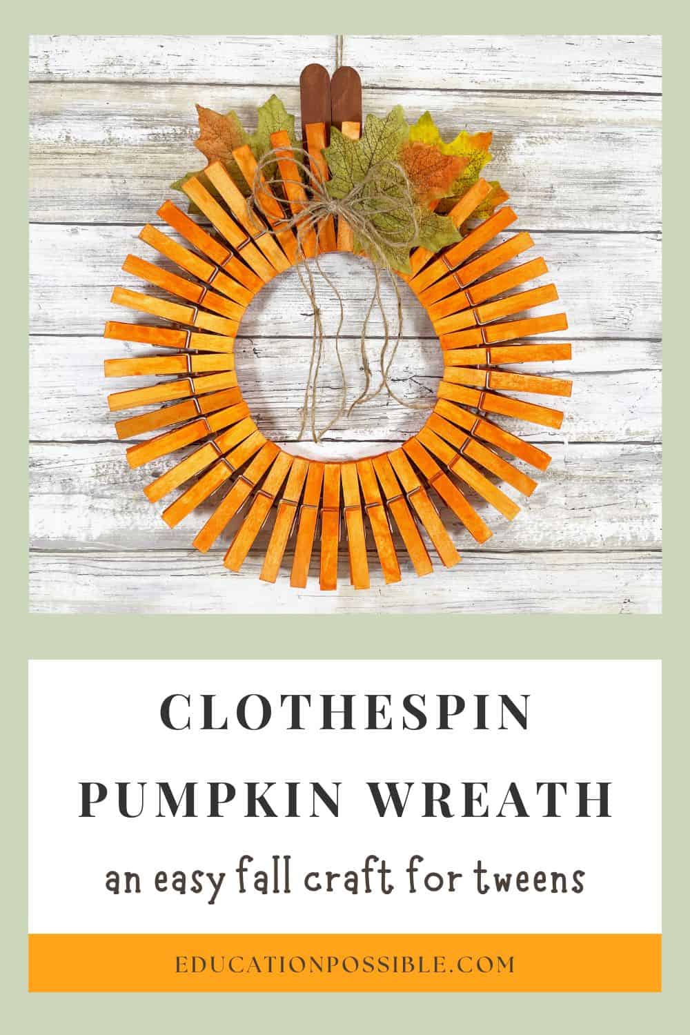 DIY clothespin pumpkin wreath craft completed and hanging on a wall