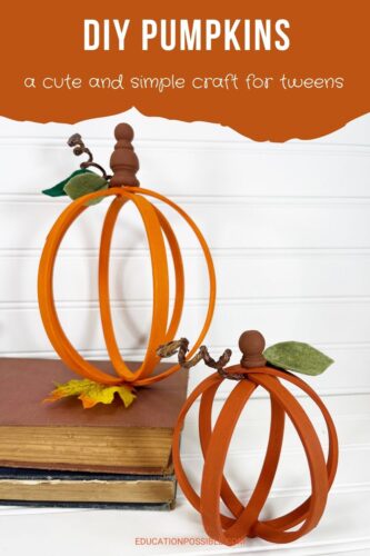 Two embroidery hoop pumpkin crafts against a white background. Taller one on top of a book.