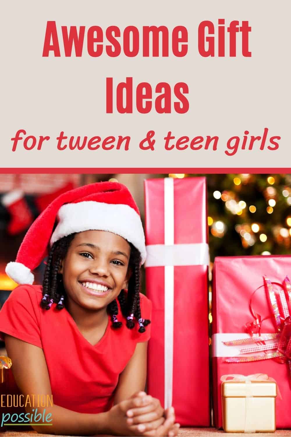 Tween African American girl wearing a santa hat, lying on the floor, up on elbows, next to red paper wrapped gifts.